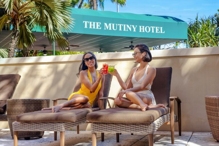 Guests lounging by the outdoor pool with cocktails